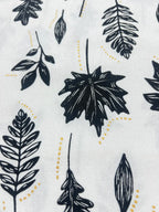 White fabric with a repeating pattern of black botanical leaf silhouettes and small dotted yellow lines.