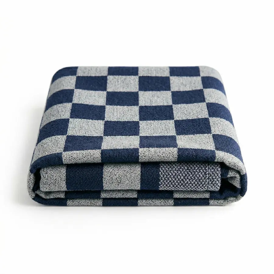 A folded throw blanket featuring a navy blue and light gray checkerboard pattern, displayed on a clean white background.